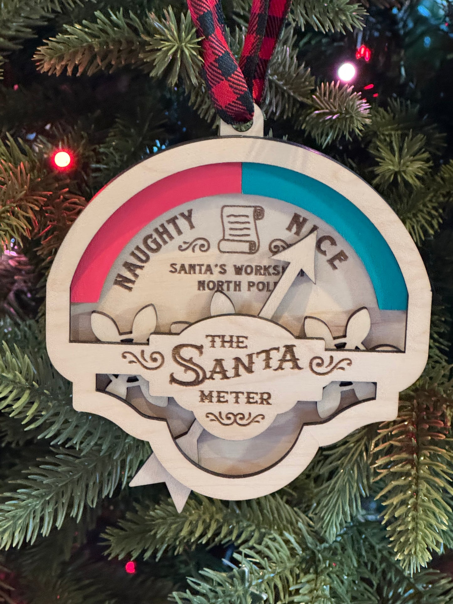 A decorative ornament in the shape of a Santa meter with a red and green color scheme, featuring text and a scale.
